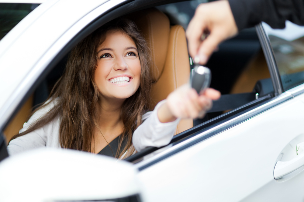 Woman being handed a new car key.