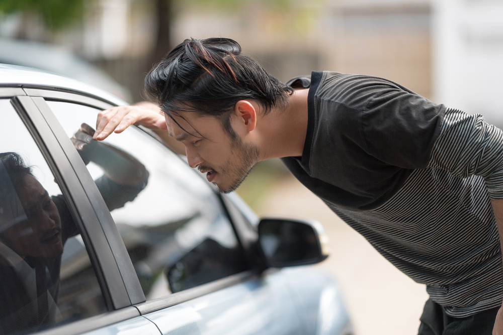 Man looking insider his car for his keys